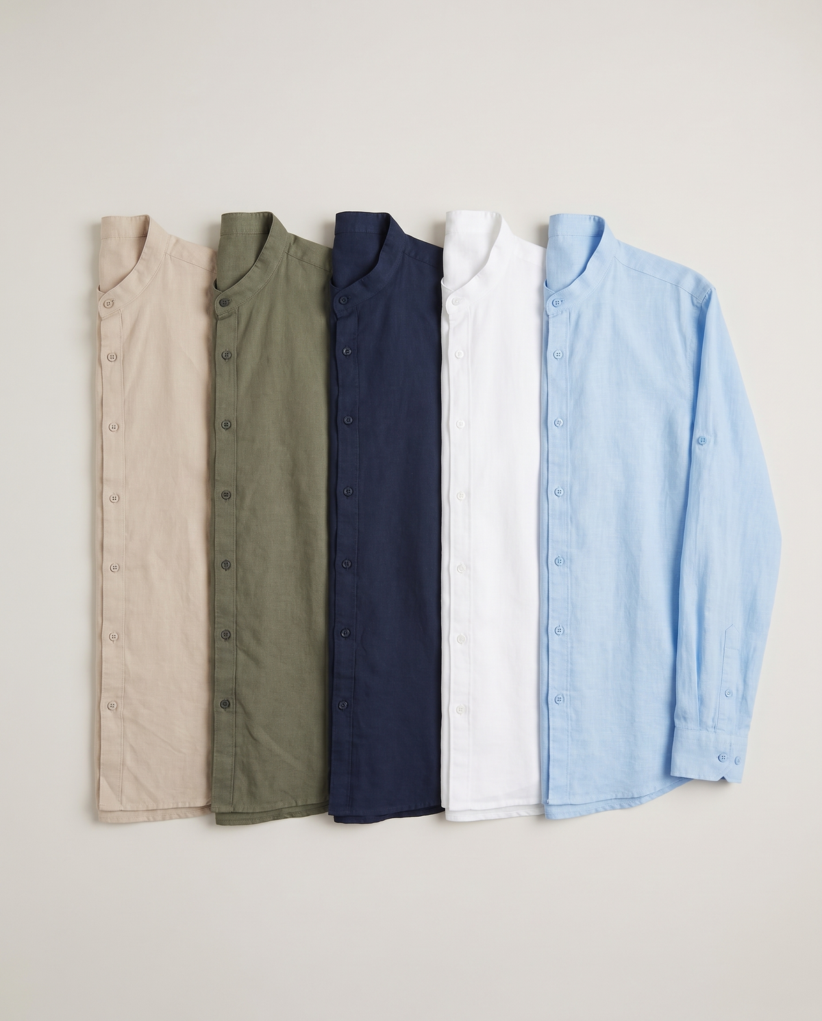 Camisa Amanecer, flat lay de los 5 colores: beige, verde caza, azul marino, blanco y celeste